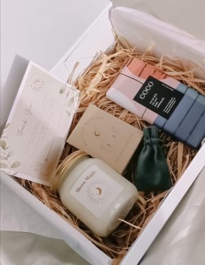 naturally elevate self-care box featuring a candle, chocolate bar, affirmation cards and a choice of three crystal pendants